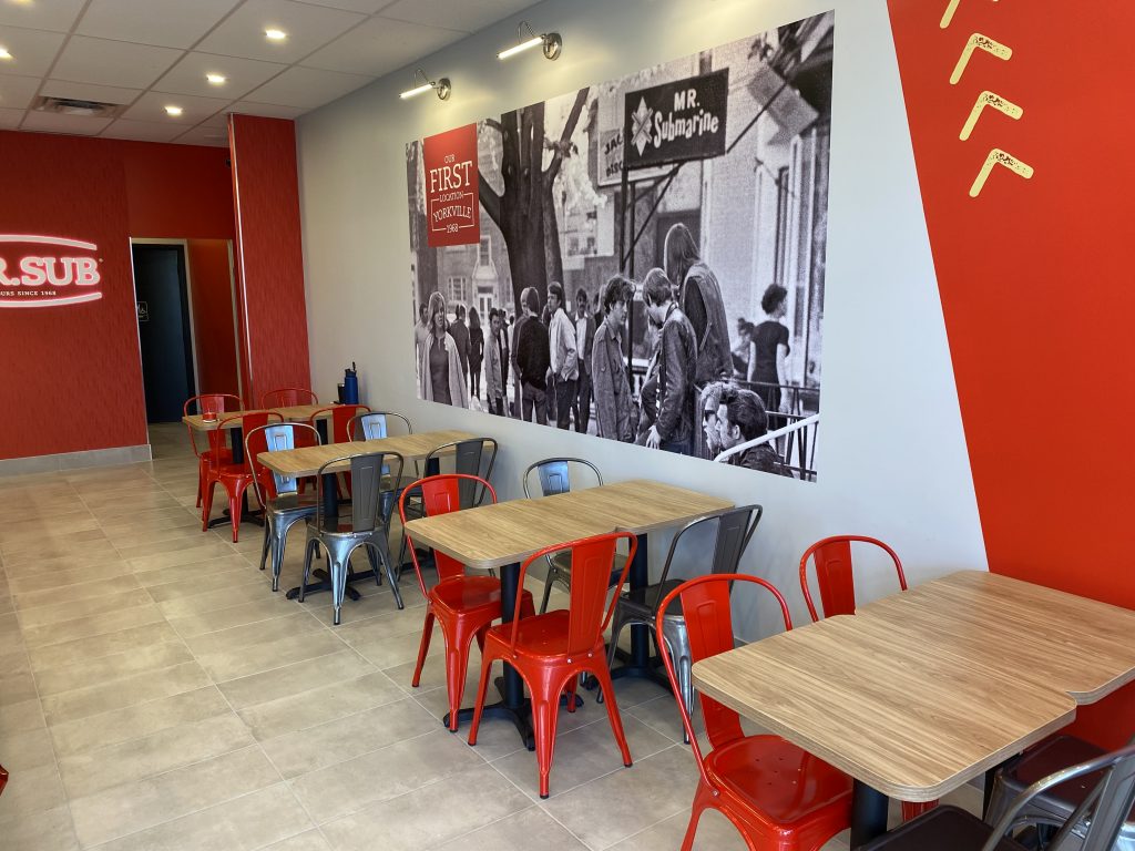 Cozy restaurant interior with modern tables and vibrant red accents.