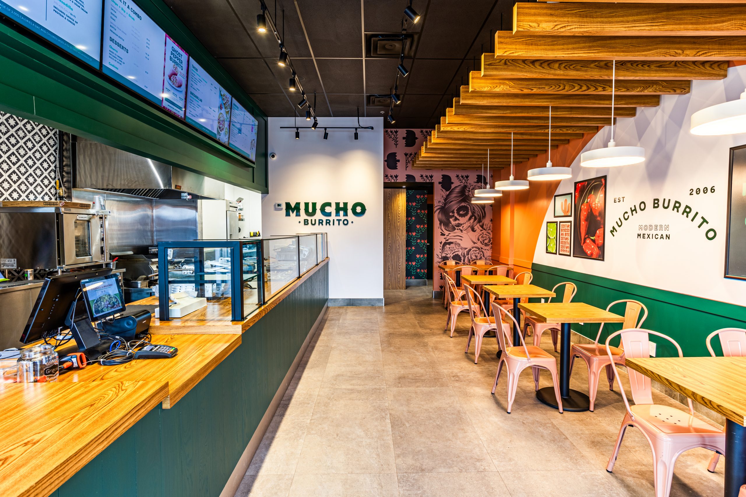 Modern restaurant interior of Mucho Burrito with colorful decor and seating.