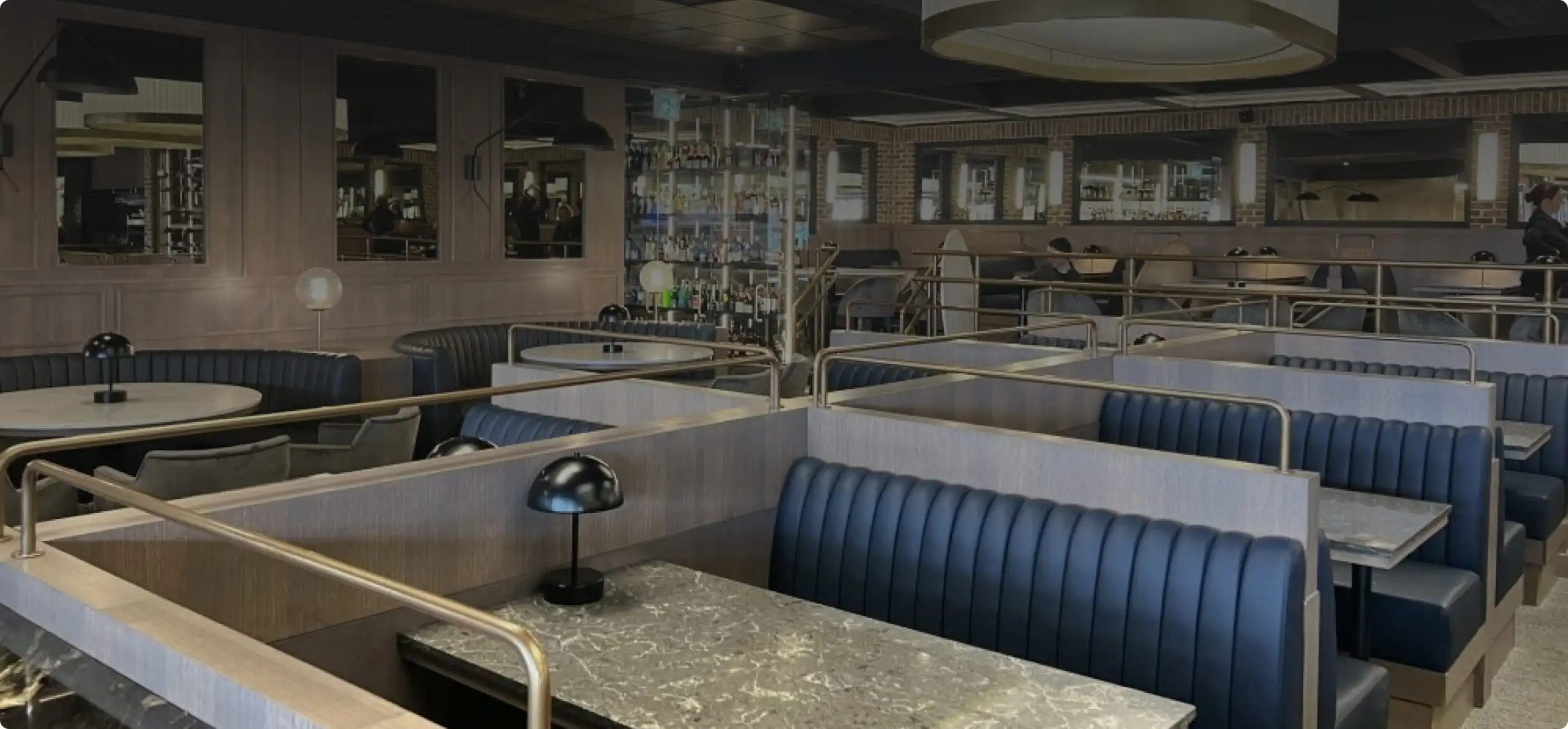 Modern restaurant interior with stylish booths and elegant lighting design.