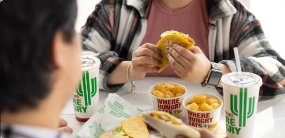 TacoTime Canada meal with crispy taco, tater tots, and drinks featuring TacoTime Canada logo / Franchising Mexican Food: A TacoTime Canada Success Story Blog