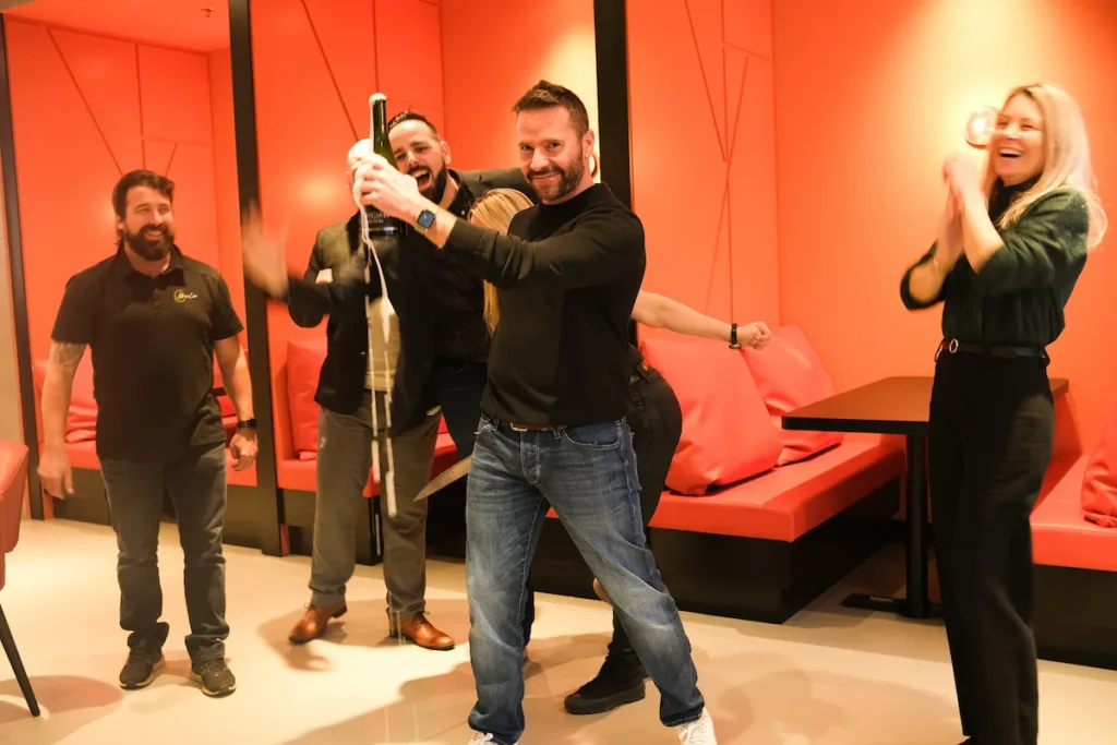 Allô mon Coco franchise opening celebration with champagne sabering — a fun, family-friendly café and brunch franchise tradition in Canada.