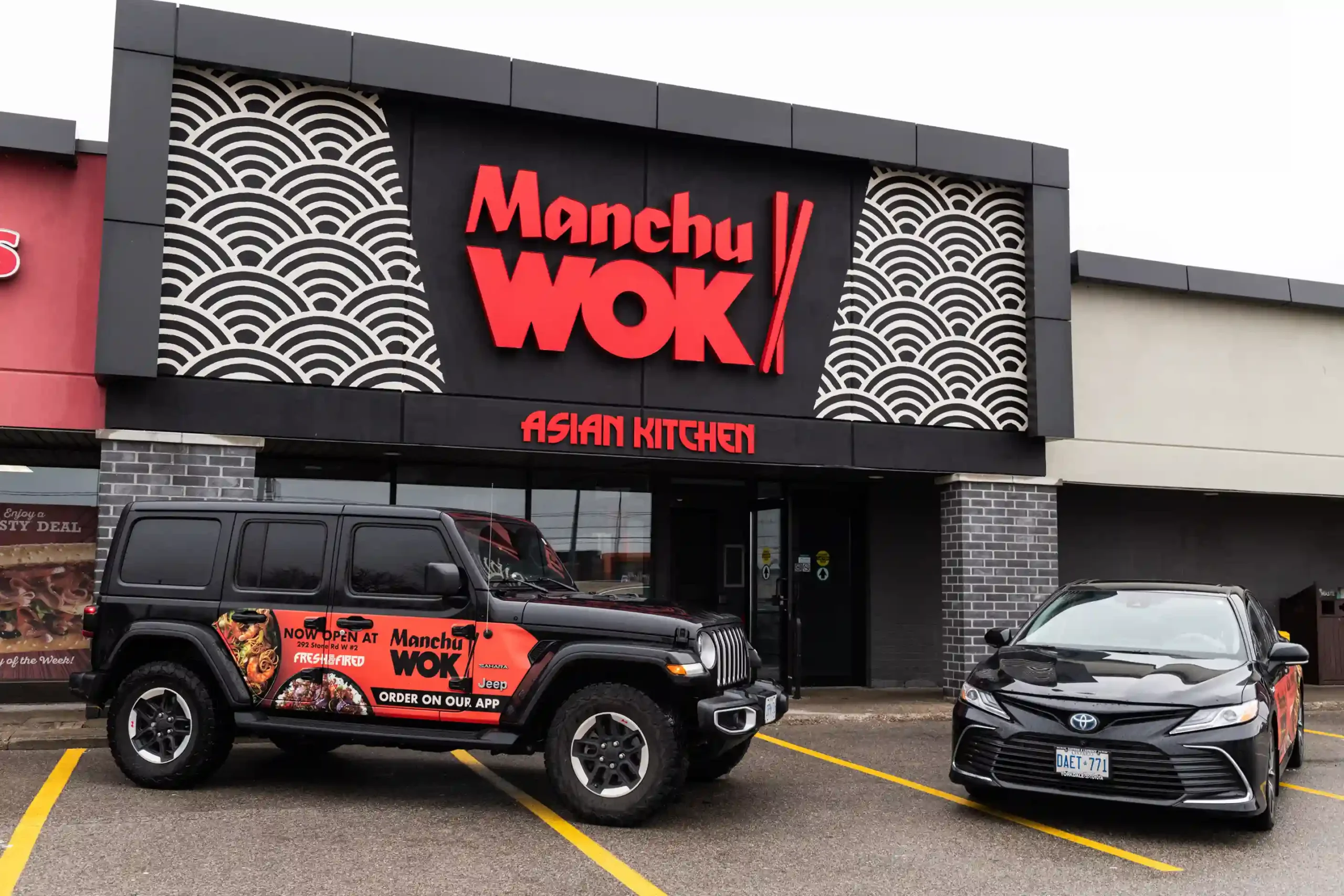 Top view of Manchu WOK takeout boxes filled with noodles, vegetables, and crispy chicken; a vibrant, authentic Chinese food franchise experience celebrating Asian flavours in Canada.  | MTY Group Franchising