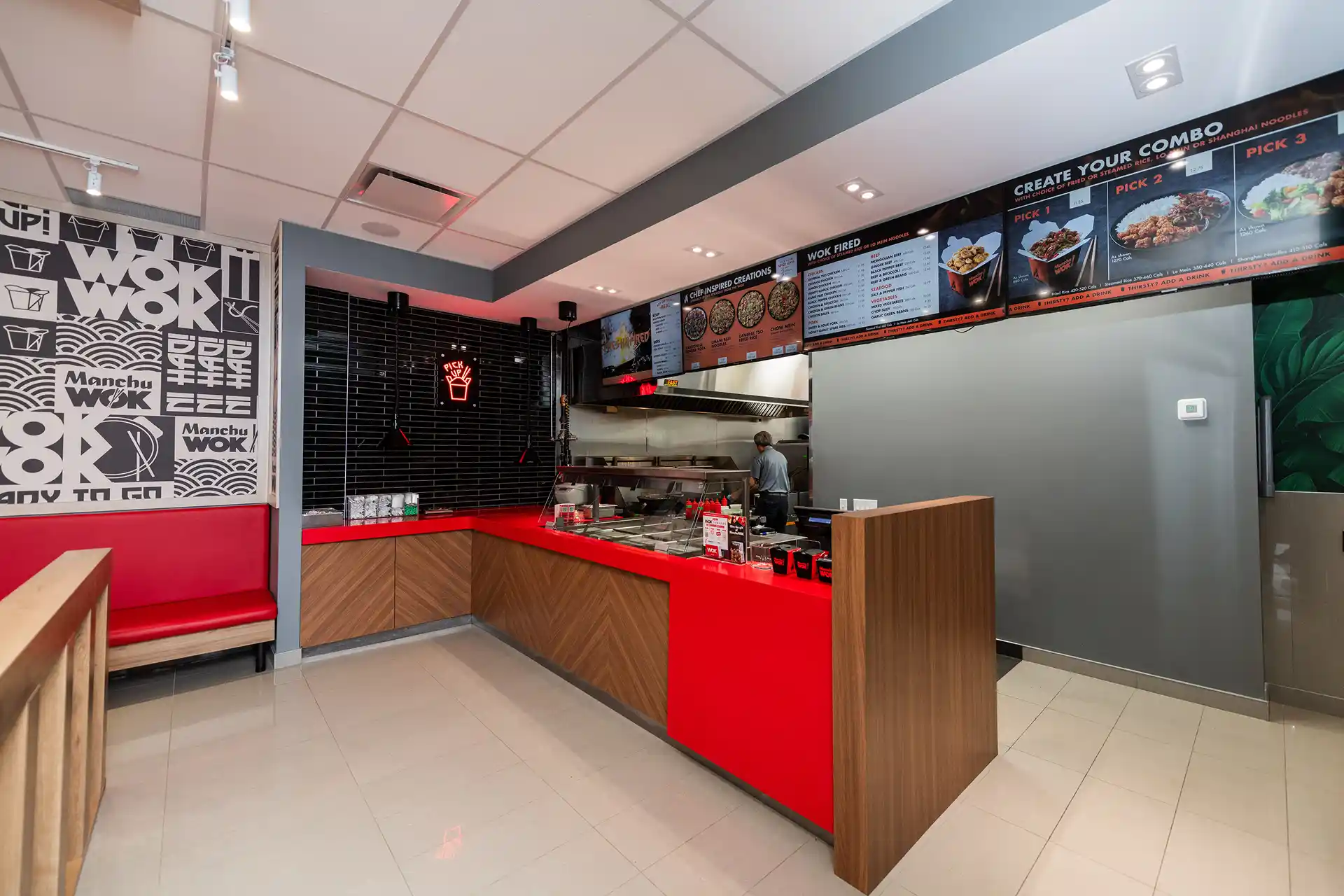 Modern Manchu WOK restaurant interior with open kitchen and vibrant red design; a bold, fast-casual Chinese WOK franchise redefining Chinese food in Canada. | MTY Group Franchising