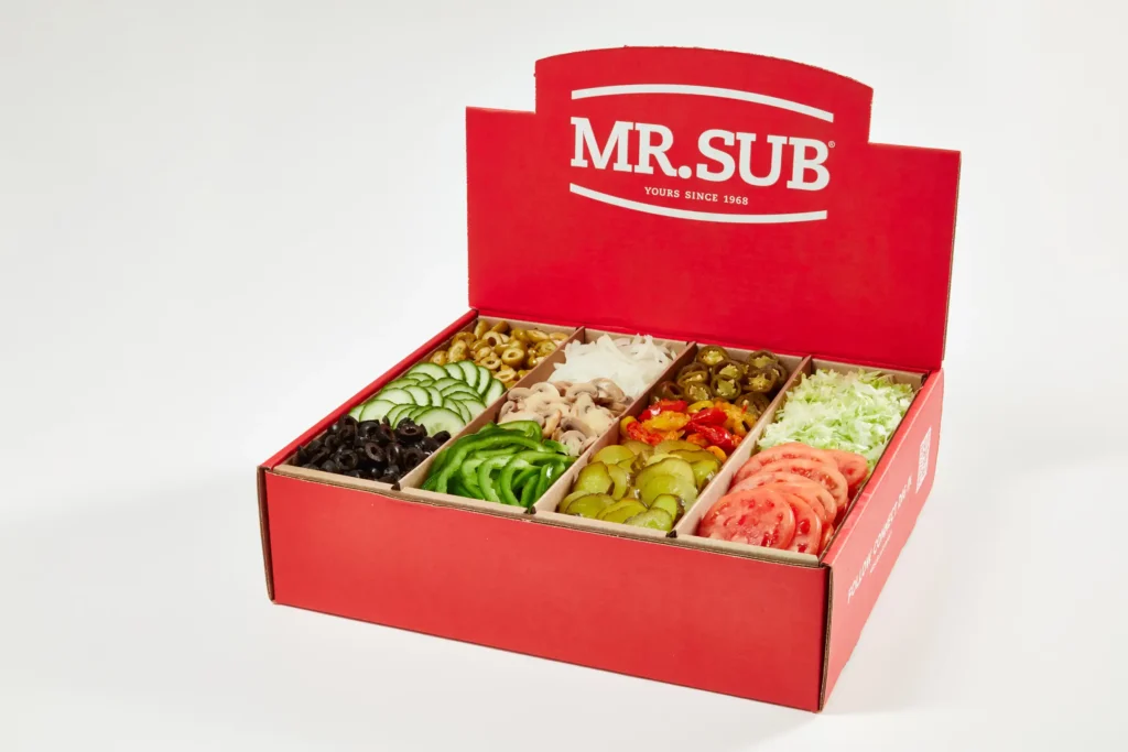 MR.SUB catering toppings box filled with fresh vegetables and sandwich ingredients, showcasing franchise-ready quality and prep efficiency.