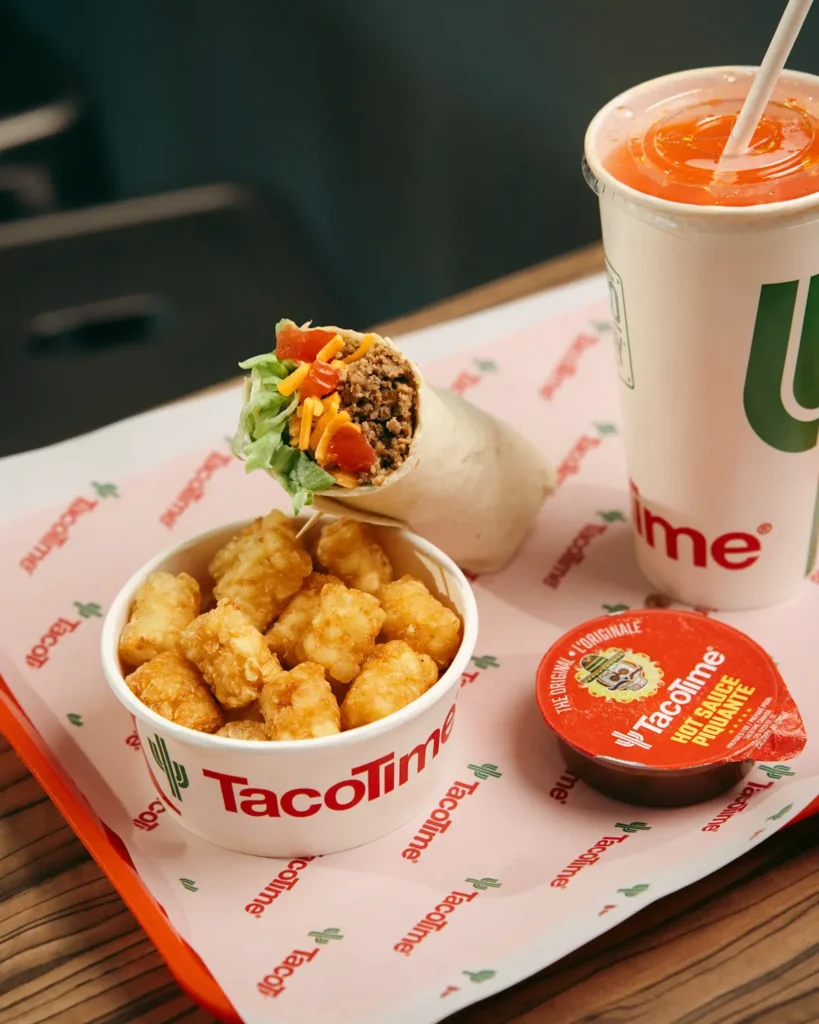 TacoTime combo meal with a beef burrito, crispy tater tots, orange drink, and hot sauce on a branded tray.
